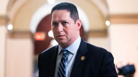 Getty Images Tony Gonzales is seen in a suit and tie walking in the US Capitol