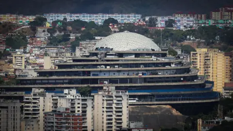 Miguel Gutiérrez, EPA/Shutterstock A large, imposing spiral concrete building sits in a densely populated city neighbourhood, surrounded by tower blocks