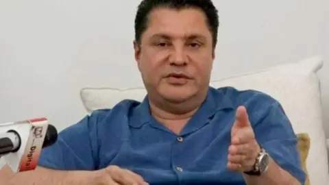 The Citizen Rostam Aziz, wearing a blue shirt, speaking at a press conference 